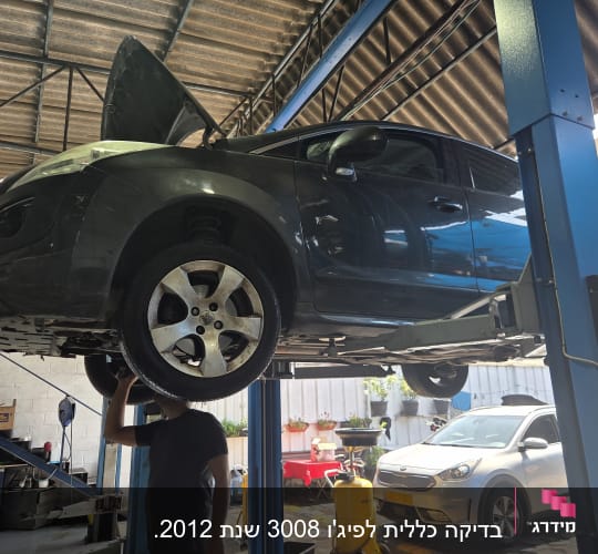 רכב על מעלית במוסך עם אדם מתחתיו